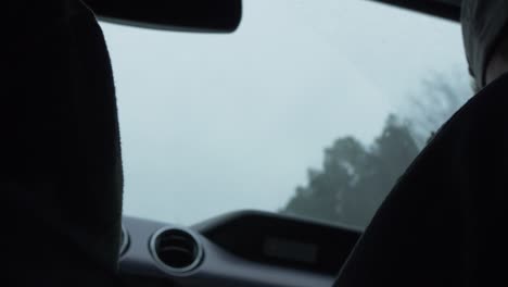 car-windshield-wipers-working-in-rain-slow-motion-passing-highway-exit-signs