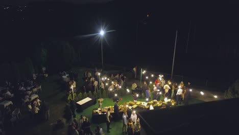 Aerial-tilt-up-shot-of-a-wedding-banquet-during-the-night-on-a-garden