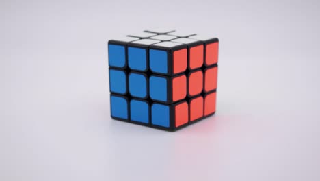 Nahaufnahme-Des-Gelösten-Rubiks-Würfels,-Der-In-Den-Rahmen-Mit-Einem-Sauberen-Weißen-Hintergrund-Fällt