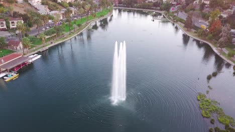 LA:-Drone-shot-of-Echo-Park-Lake-and-Fountain-with-Downtown-Skyscrapers-in-the-distance-at-sunset