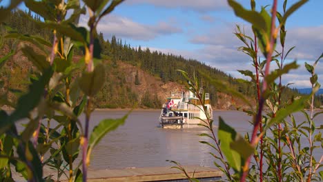 Steam-Boat-Leaving-Dock-in-whitehorse-Canada-with-leaves-blowing-in-the-foreground
