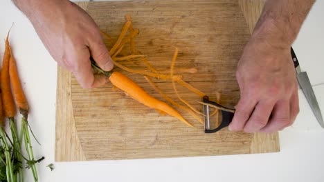 Overhead-of-chef-peeling-organic-carrots