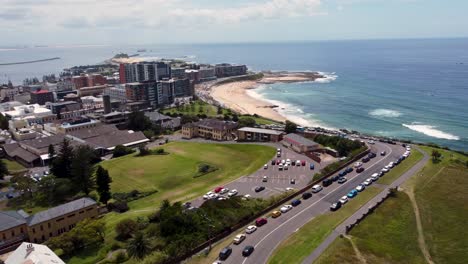 Aerial-scenic-drone-view-of-sandy-Newcastle-Beach-roads-and-city-CBD-Cooks-Hill-Bar-Beach-tourism-Pacific-Ocean-NSW-Australia-4K