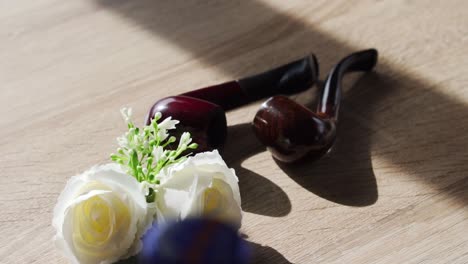 Kleine-Hochzeitsdetails-Mit-Holzpfeife-Und-Blumen-Auf-Dem-Tisch