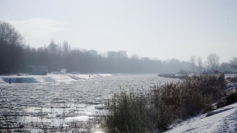 Gefrorener-Fluss-Mit-Eisschollen-Im-Winter-Mit-Wohnblock-Im-Hintergrund