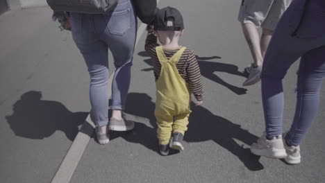 Slow-Motion,-Single-Young-Boy-walking,-holding-Mothers-Hand-walking-with-Adult-group