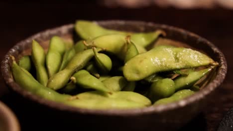 Hand-picking-up-from-bowl-of-edamame-beans