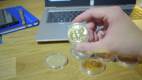 Young-Male-Businessman-In-His-Office-Holding-Physical-Bitcoin-In-His-Hands