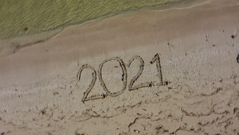 Twenty-Twenty-One-written-in-the-sand-and-spinning-clockwise-showing-it-as-a-crazy-year