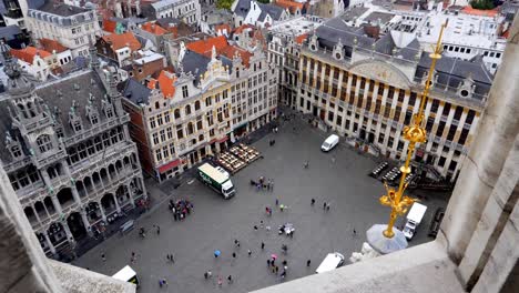 Top-view-from-City-Hall-tower-overlooking-the-Grand-Place-with-people-and-vehicles-below,-Slow-Motion-Handheld-dolly-in