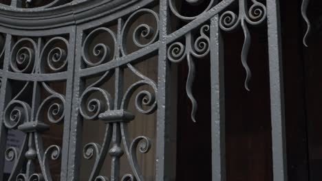Old-wrought-gate-on-church-entrance-door-panning-shot
