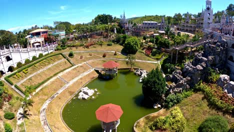 Stable-view-of-the-greeny-water-pond-at-the-center,-surrounded-by-the-beautiful-structure-of-gothic-historic-Cathedral-Simala-Church-in-Cebu,-Philippines