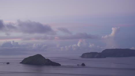 Silhouettes-Islands-at-early-morning-dusk-with-low-hanging-clouds---locked-off-tight-shot
