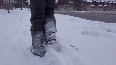 Niño-Caminando-En-La-Nieve-Usando-Pantalones-De-Nieve,-Botas-De-Nieve,-Guantes-En-Zona-Urbana-En-Invierno