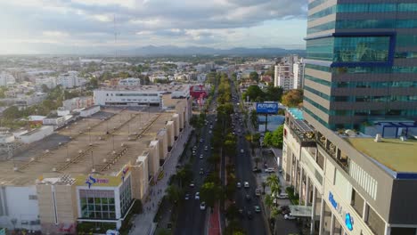 Drone-flies-over-a-busy-city-street-filled-with-cars-in-urban-Santo-Domingo-during-Rush-hour,-Aerial-Dominican-Republic