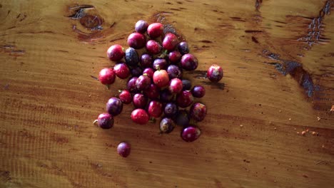 Close-up-shot-of-ripe-red-berry-coffee-beans-on-wooden-table