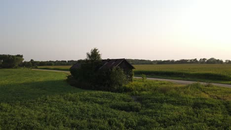 Aerial-footage-lonely-old-shack-in-Minnesota-during-summer-time,-farms,-country-side,-fields