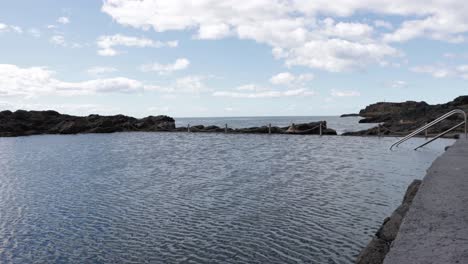 Kiama-Ocean-Rock-Pool-in-New-South-Wales-Australia-with-ladder-entering-water,-Locked-shot