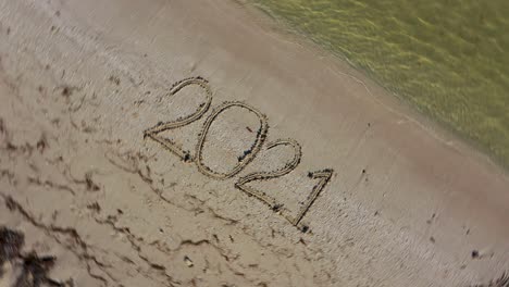 Twenty-Twenty-One-written-in-the-sand-and-spinning-counterclockwise-continuously-making-it-a-crazy-year