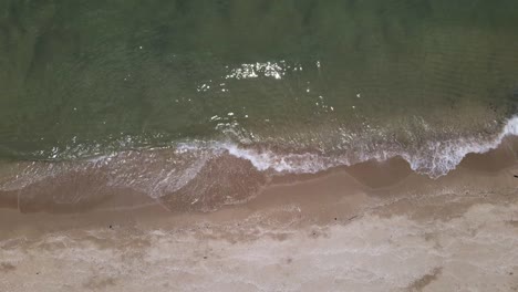 Drohne-Vertikale-Statische-Aufnahme-Von-Wellen-In-Zeitlupe,-Die-Sanft-An-Einem-Tropischen-Strand-Zusammenbrechen