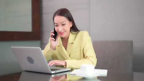 Successful-young-Asian-girl-in-a-modern-office-in-yellow-suite
