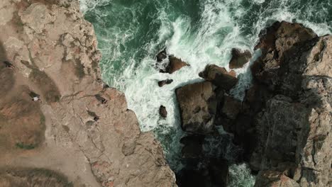 drone-fly-above-rocky-coastline-with-ocean-water