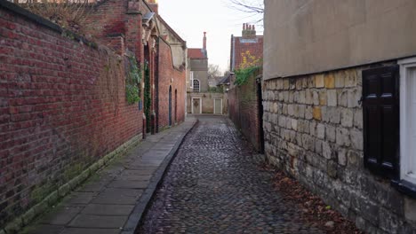 Slow-dolly-in-down-old-fashioned-cobble-street-in-historic-city-of-York