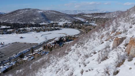 Incredible-aerial-drone-shot-taking-off-up-and-over-Park-City,-Utah-after-a-snowfall
