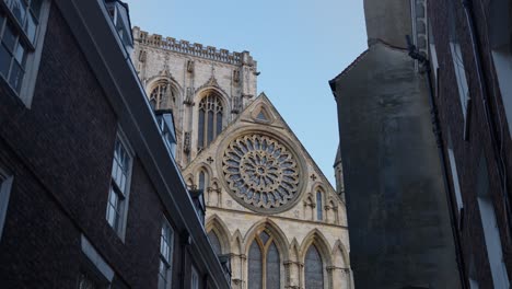 Slow-establishing-teaser-shot-of-York-Minster-cathedral-at-sunrise-through-the-narrow-cobbled-streets-of-York