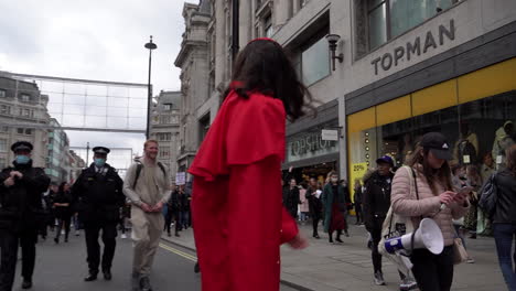 A-man-dressed-in-a-red-Catholic-Cardinal-smock-walks-at-the-front-of-a-Coronavirus-and-QAnon-conspiracy-protest