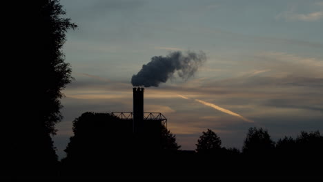 Schöne-Silhouette-Des-Rauchenden-Fabrikschornsteins-Gegen-Einen-Sonnenuntergang-In-Zeitlupe