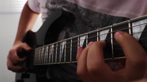 Close-up-of-man-playing-guitar,-moves-fingers-along-strings