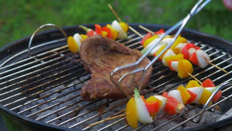 Flank-steak-mixed-with-vegetables-on-a-skewer-being-grilled-over-hot-coals