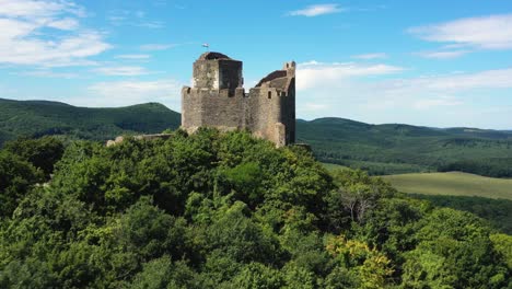 Drone-footage-about-Ruins-of-an-old-castle-from-the-middle-ages-at-Holloko,-Hungary-Drone-flies-backwards-and-over-the-castle