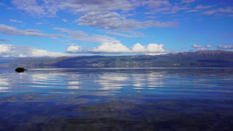 Lake-panorama-with-clean-calm-water-reflecting-beautiful-clouds-on-blue-sky
