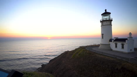 Lighthouse-Tower-on-Top-of-Hill-and-Sunset-Above-Pacific-Ocean-on-Skyline,-Cape-Disappointment,-American-Coastline-and-19th-Century-Landmark,-Panorama