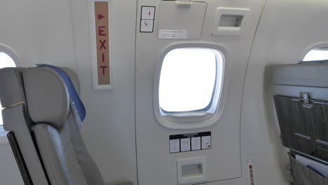 Emergency-exit--Inside-an-airplane-during-travel--Tilt-up