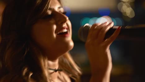 Beautiful-Caucasian-Woman-Enjoying-Singing-On-Stage-With-Bokeh-Lights-In-The-Background