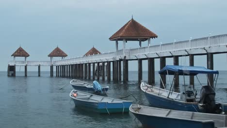 Static-wide-shot-of-parking-fishing-boats-and-empty-jetty-during-cloudy-day-in-Malaysia