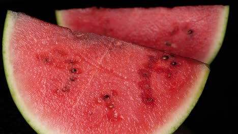 Close-up-pan-shot-of-fresh-watermelon-piece-with-black-seed,black-background