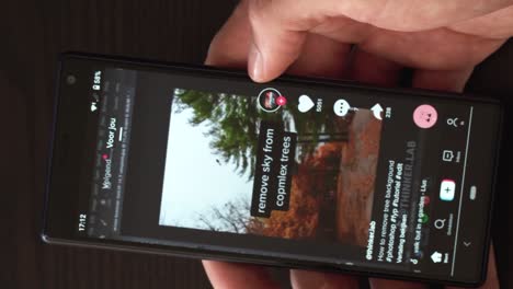 Vertical-video-of-hand-scrolling-on-smartphone-with-TikTok-feed-on-the-screen
