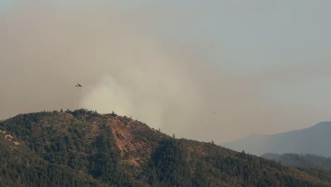 Smoke-jumper-plane-flies-by-massive-wildfire-in-the-mountains
