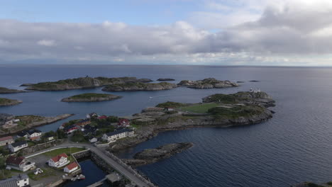 Aerial-shot-showing-a-fishing-village,-small-islands-and-a-football-field-in-Lofoten,-Norway