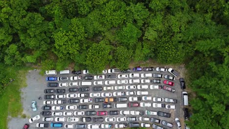 AERIAL:-Drone-lowers-altitude-and-lands-in-a-Pick-Up-truck-above-Parking-Zone-full-by-Cars-what-stuck-in-the-Queue-waiting-for-Ferry-from-Koh-Chang-Island-to-Mainland,-Thailand,-Asia