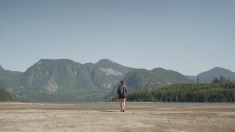 Woman-walking-towards-beautiful-mountain-landscape-view-with-lake