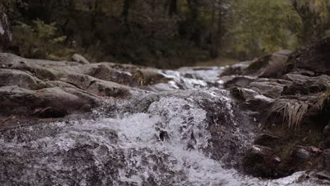 Jib-Slow-Motion-Shot-of-River-Rapids-with-Water-Splashing-on-Rocks