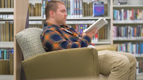 Man-sits-in-the-library-reading-a-book