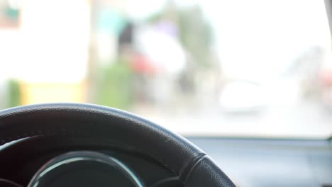 POV-to-the-car-steering-wheel-while-driving-on-the-road-in-soft-focusing