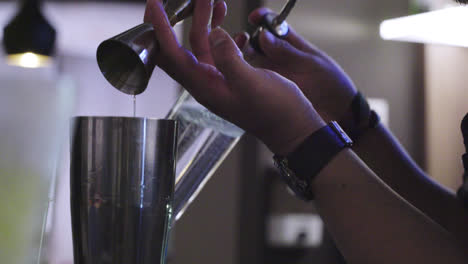Close-up-of-a-bartender-pouring-ounces-of-drink