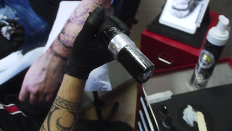 Professional-tattoo-artist-refills-his-wireless-tattoo-machine